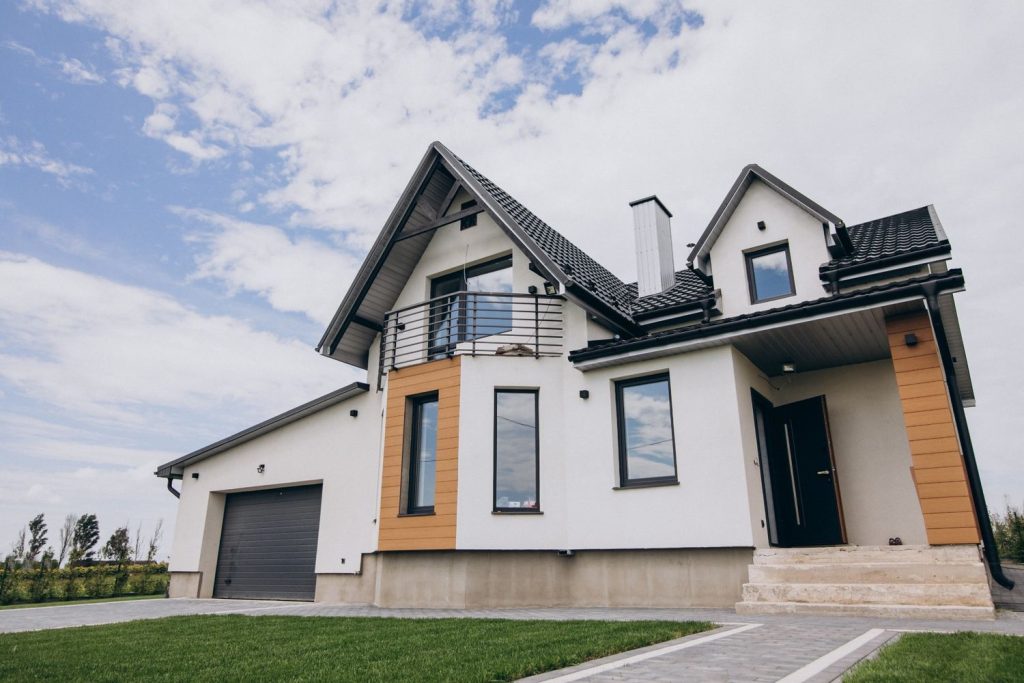 A modern white house with a garage, showing how to afford your dream home through smart financial planning.