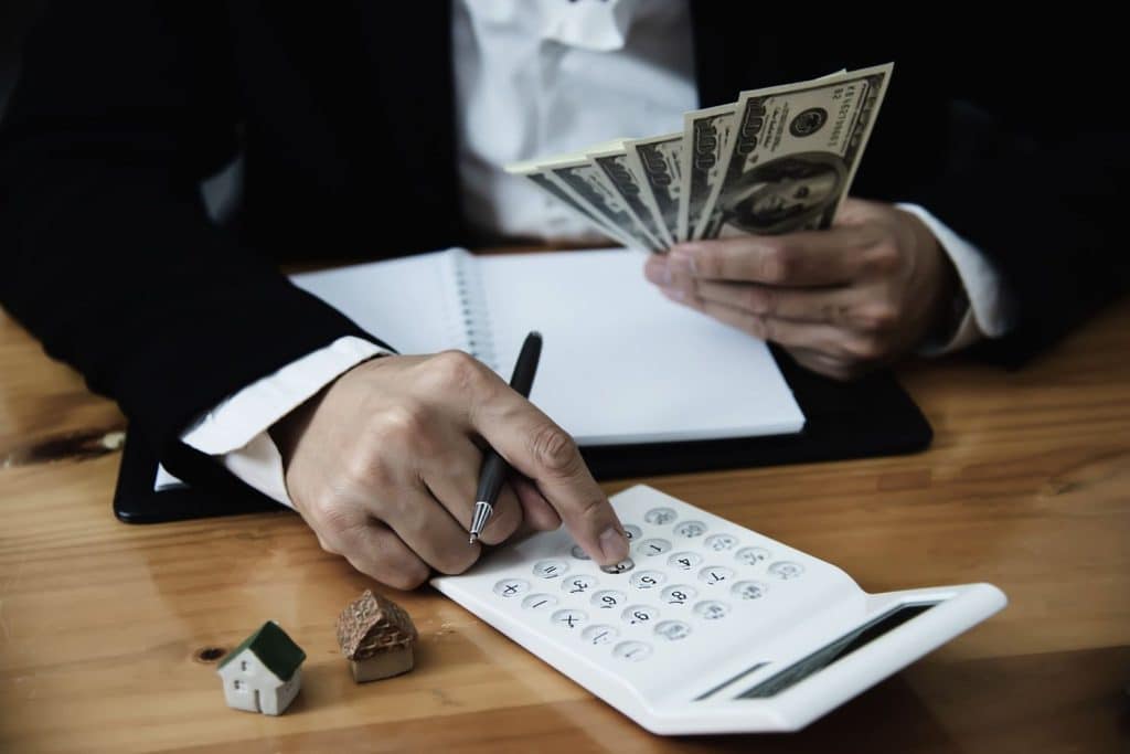 An individual uses a calculator to estimate monthly repayments and total costs of personal loans.