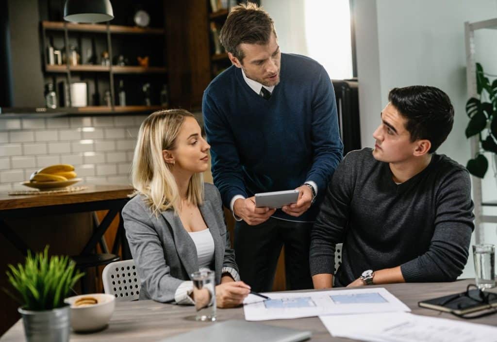 A couple reviews home renovation plans with an expert to determine the necessary amount for personal loans.