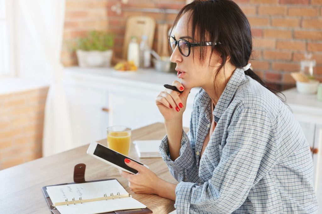 A woman researching financial tips on a tablet to learn how to remove mortgage insurance and save on home costs.