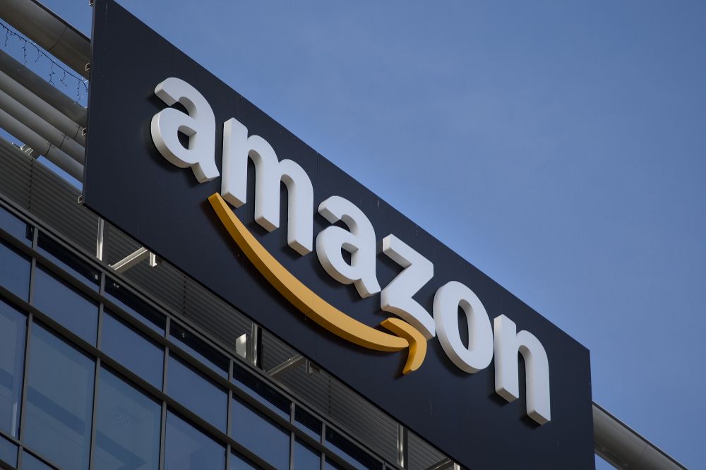 Amazon logo sign on company office building exterior against clear sky