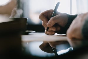 Person writing a debt settlement letter
