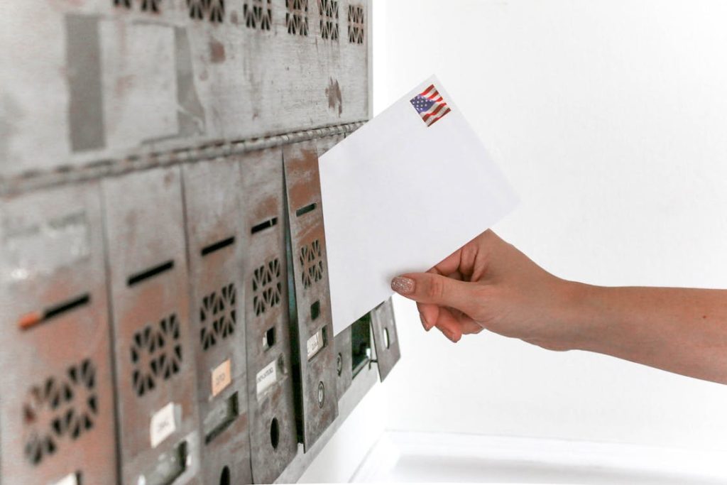 Person inserting a debt settlement letter in a mailbox