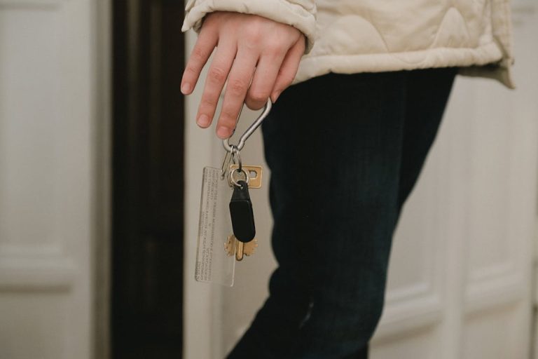 Hand of a woman holding key to her tenants by severalty owned house