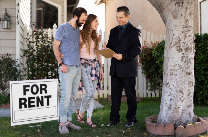 Couple handshaking a realtor after accepting a rental agreement with flex rent payment