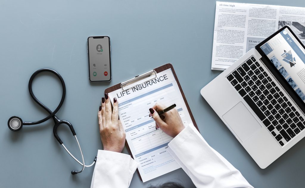 Doctor filling up a life insurance form with coinsurance policies