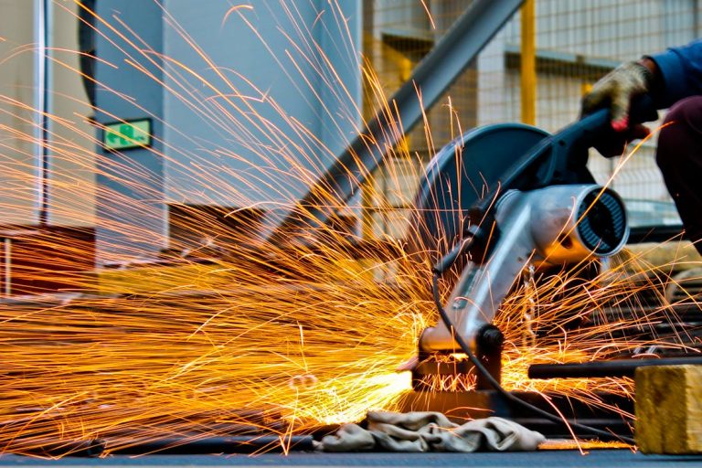 Cut-off saw cutting metal with sparks for Nippon Steel news