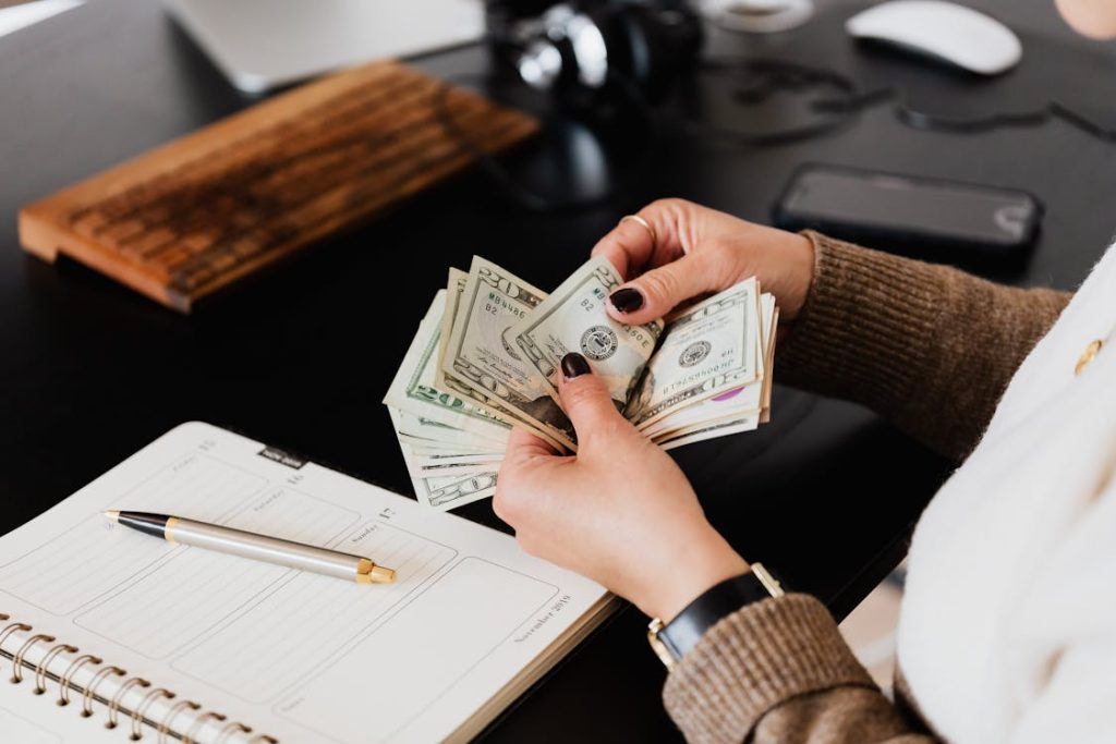 Person living paycheck to paycheck counting paper bills