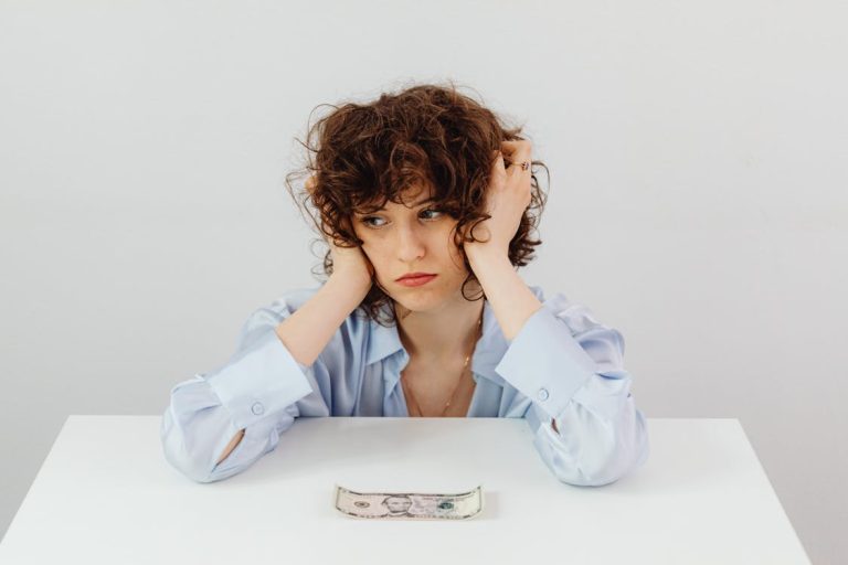 A stressed girl with one bill on the table living paycheck to paycheck