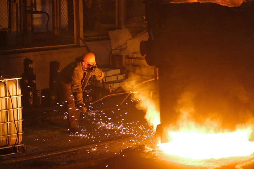 Man in helmet and mask welding steel for Nippon Steel news