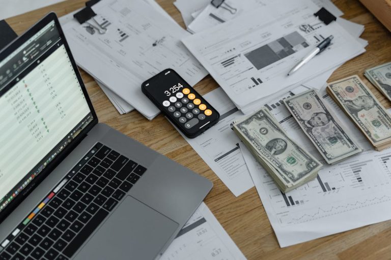 Money, calculator, and laptop on the table to plan for tax-free investment accounts