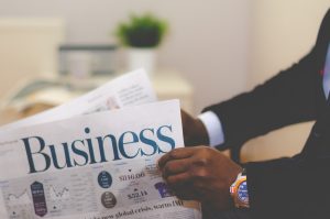 Man holding a business newspaper for examples of sole proprietorship