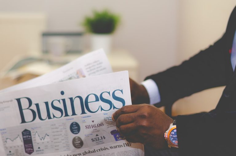 Man holding a business newspaper for examples of sole proprietorship