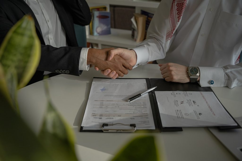 People handshaking after signing partnership agreement for partnership examples