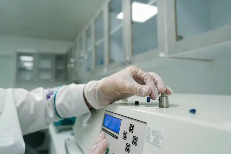 A person in a lab coat with gloves working in a lab for Vivo Capital