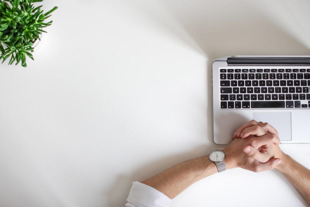 Man holding his hands together on top of laptop for examples of sole proprietorship