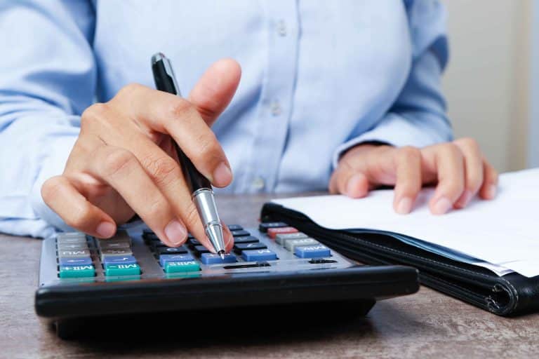 Closeup of hand calculating the Treynor ratio on a calculator