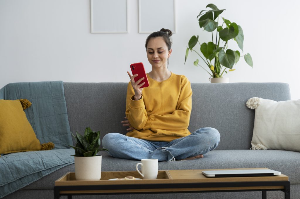 Woman sitting on grey couch using direct debit