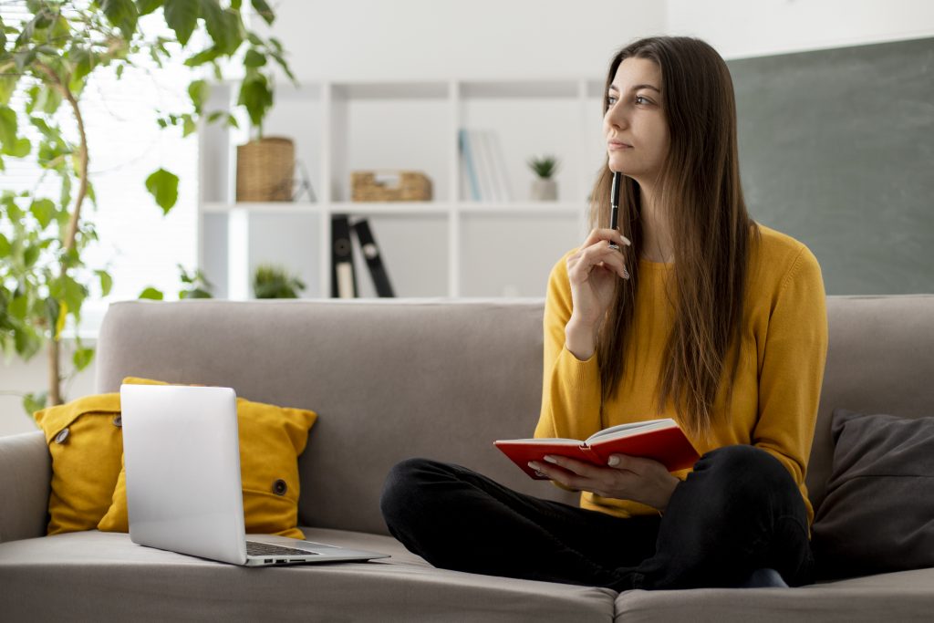 Full shot of woman sitting on a couch thinking