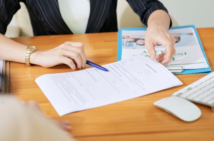 Insurance agent asking a new policyholder to sign the insurance contract