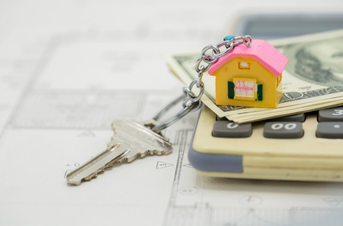 House key on top of calculator and bills