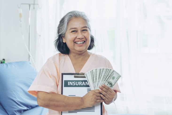 Woman holding insurance policy and paper bills