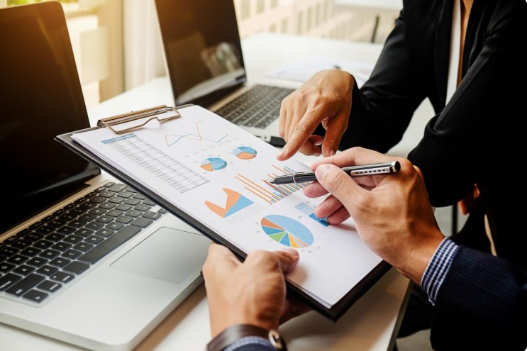 Two people viewing a business report about contribution margin