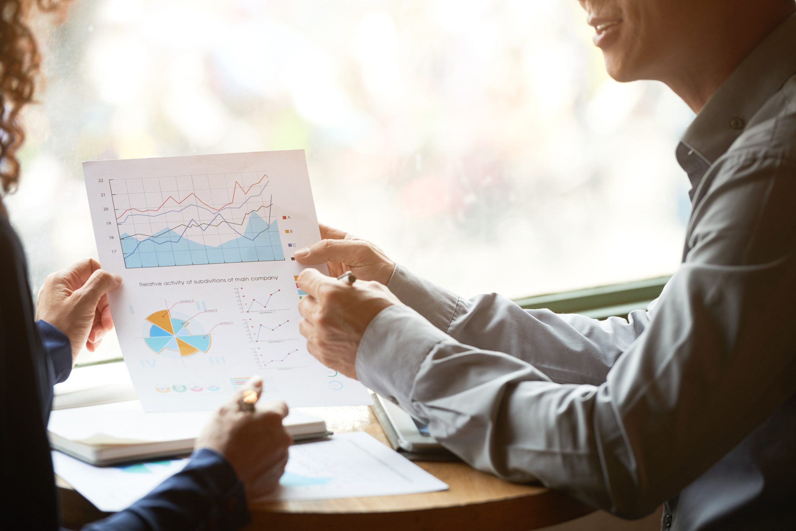 Cropped image of businessman showing charts and contribution margin graphs to his coworker