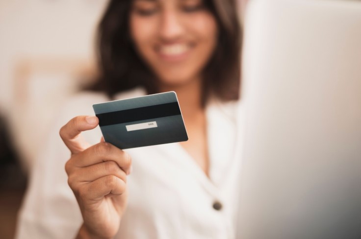 Woman holding a credit card when checking charge vs credit card
