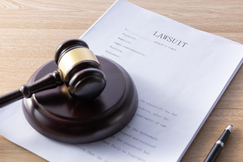High angle shot of gavel on top of structured settlement papers on a wooden surface