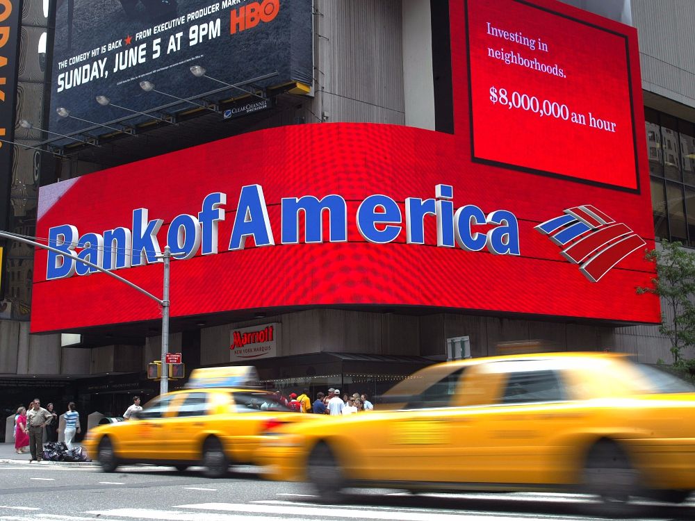 Bank of America billboard in Times Square with red display reading “Investing in neighborhoods. $8,000,000 an hour.” for Bank of America news