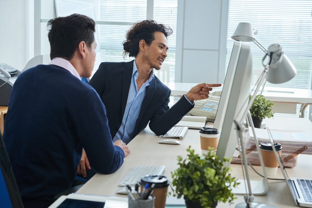 Paraplanner showing information on computer screen to his colleague