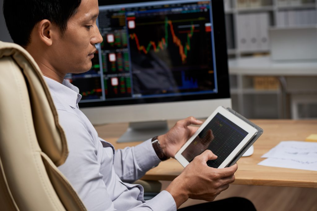 Proprietary trader analyzing proprietary trading information on tablet computer