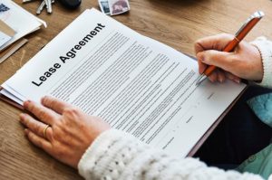 Person signing a lease agreement after rental history report approval