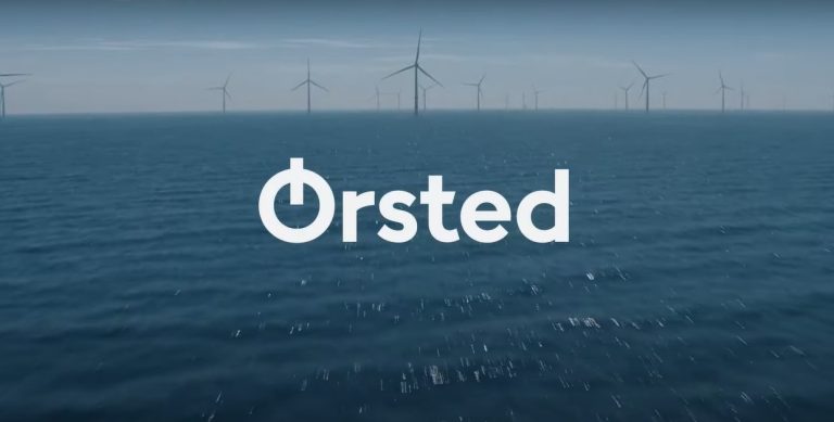 Orsted logo overlay on a full shot of offshore wind farm