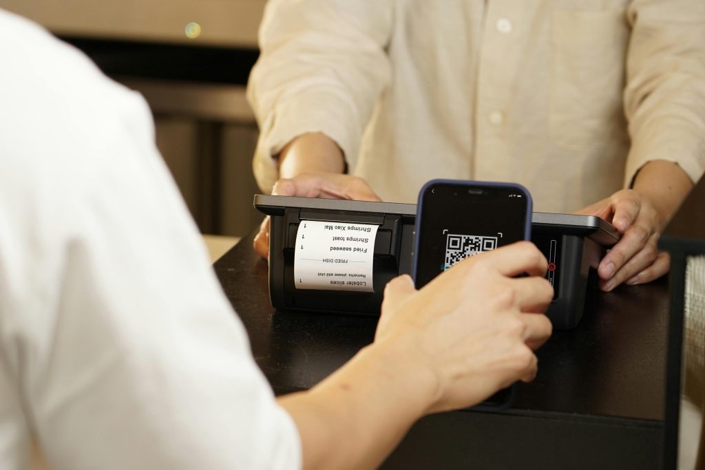 Person scanning a payment QR code via smartphone