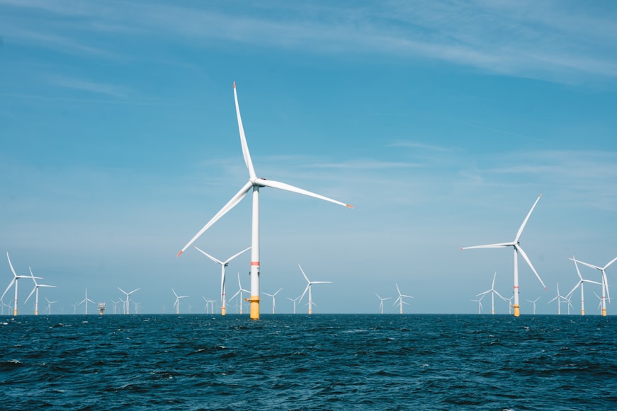 Full shot of offshore wind farm with white wind turbines in the ocean