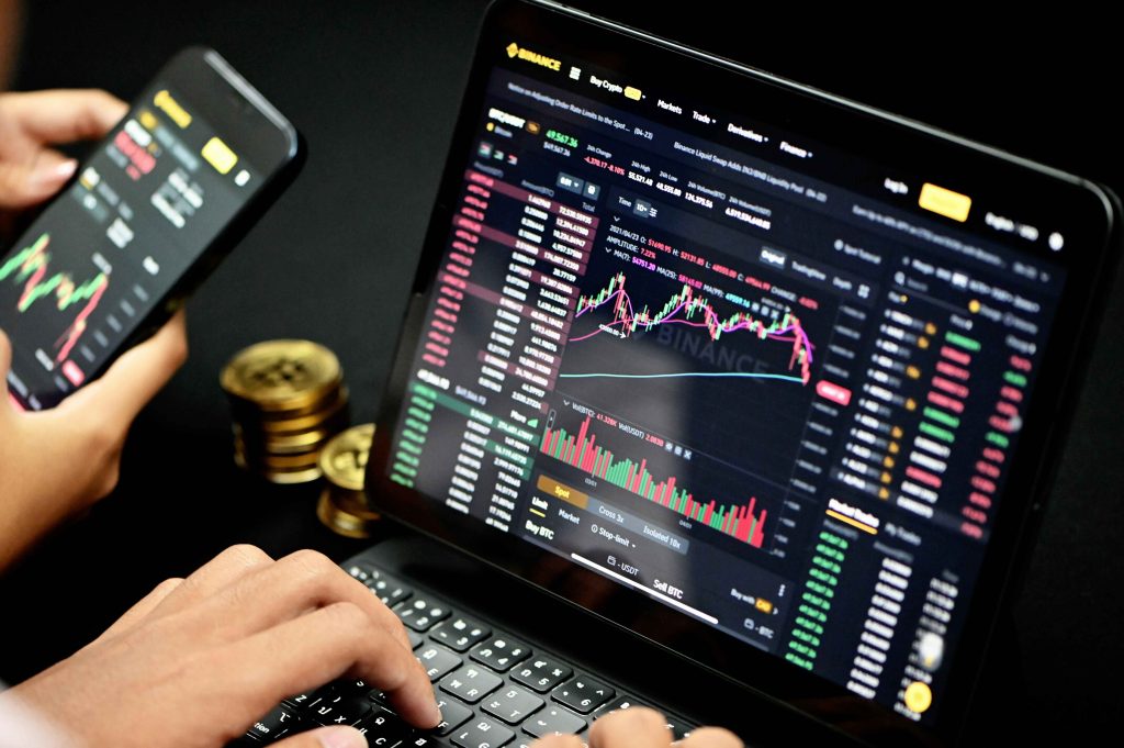 Crypto trading with live Bitcoin charts and market analysis on laptop and smartphone.