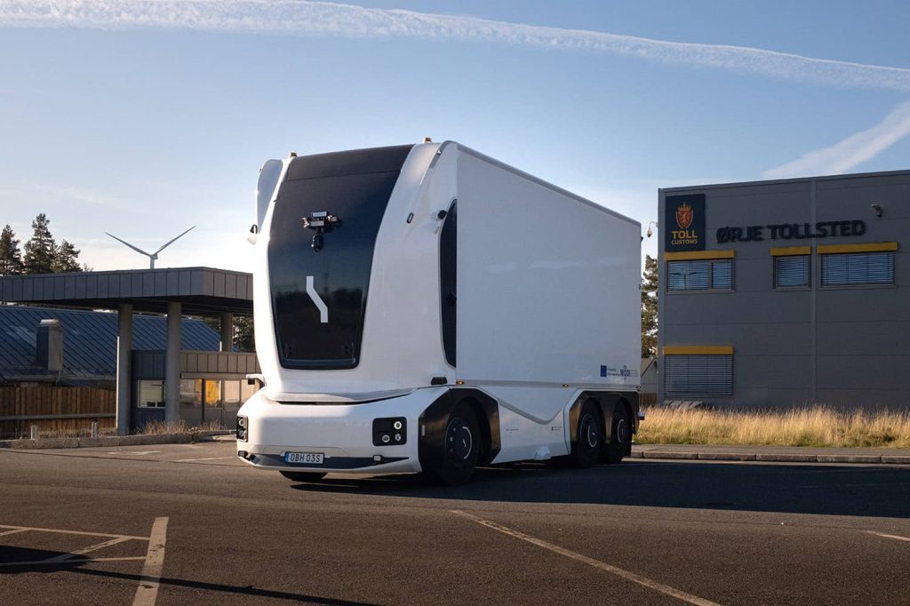 Einride autonomous electric truck driving near Ørje Toll Customs station in Norway, showcasing sustainable self-driving freight technology.