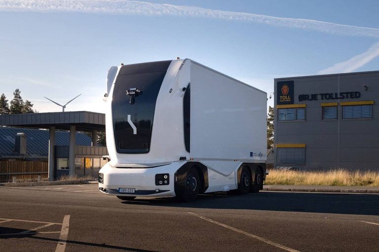 Einride autonomous electric truck driving near Ørje Toll Customs station in Norway, showcasing sustainable self-driving freight technology.