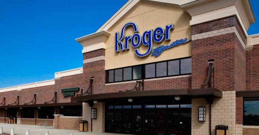 Front view of Kroger Signature supermarket with Starbucks Coffee storefront under clear sky.