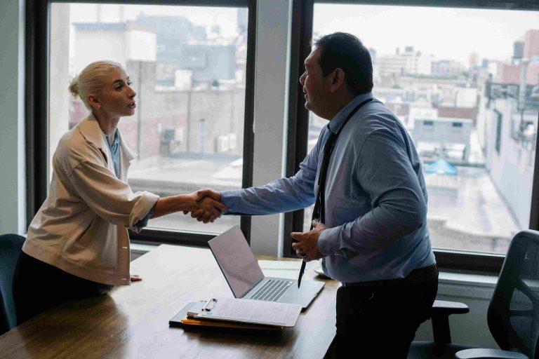 Business professionals finalizing a vesting agreement with a handshake during a corporate meeting