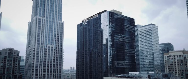 Xanadu office building in downtown Toronto surrounded by modern skyscrapers under cloudy sky.