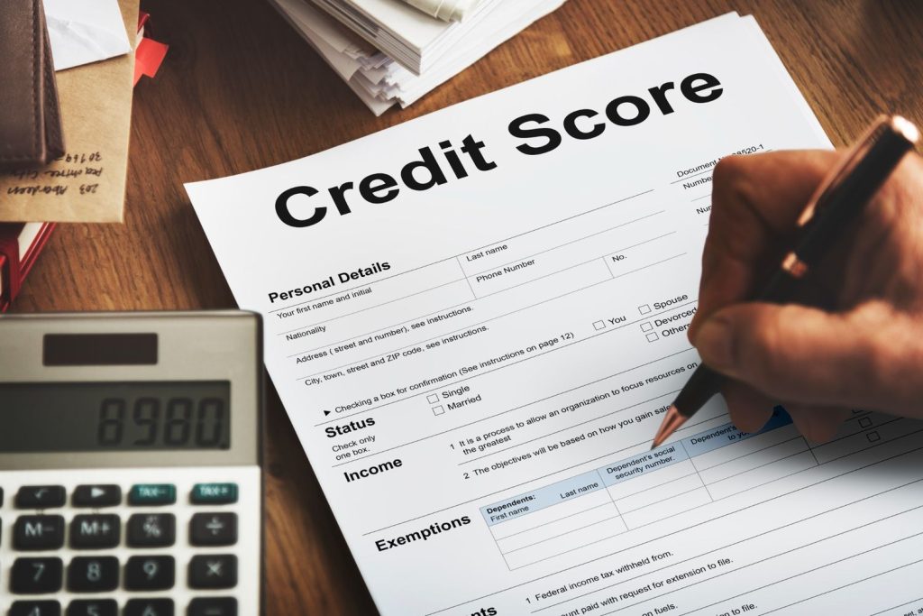 Person writing on a paper that says credit score