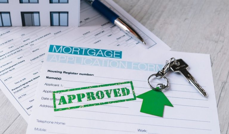 Application form with a green "Approved" stamp and house keys; perfect for explaining what is a mortgage.