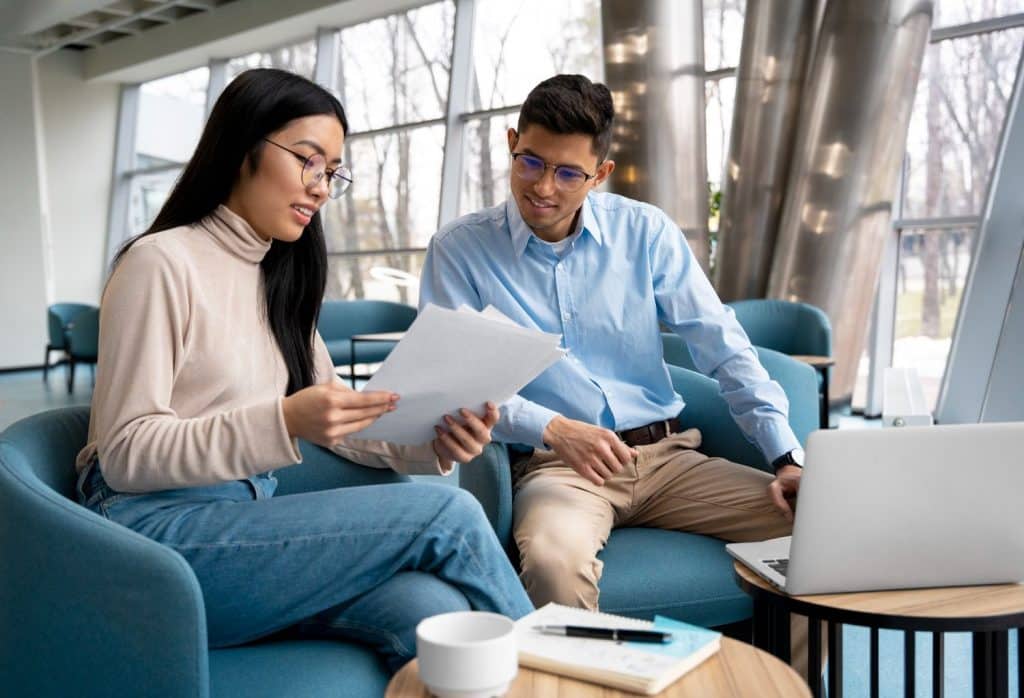 Two people reviewing paperwork for unsecured loans in a bright, modern office setting.
