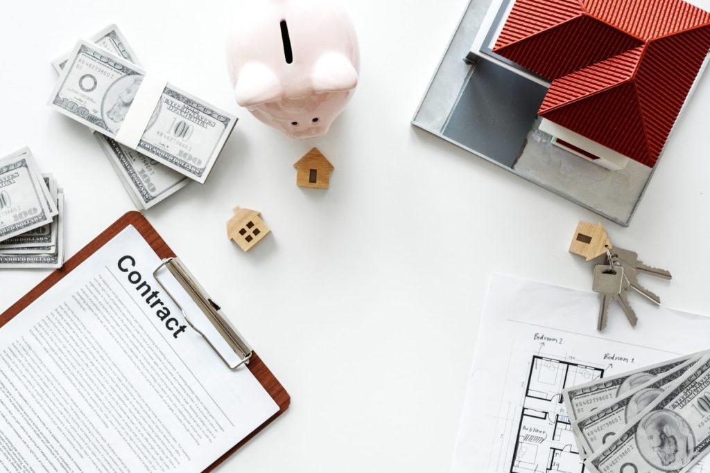 Top-down view of a loan agreement, piggy bank, and money, symbolizing the process of applying for collateral loans.