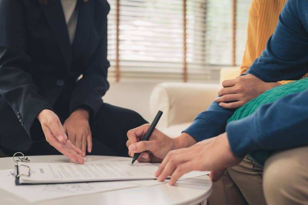 A couple discusses a secured loan with an agent to finalize their new home purchase.
