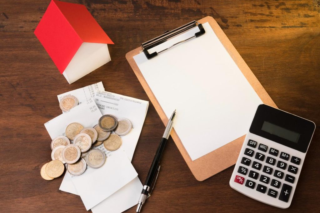 Stacks of cash, coins, and house keys on a desk, illustrating assets used to secure collateral loans.