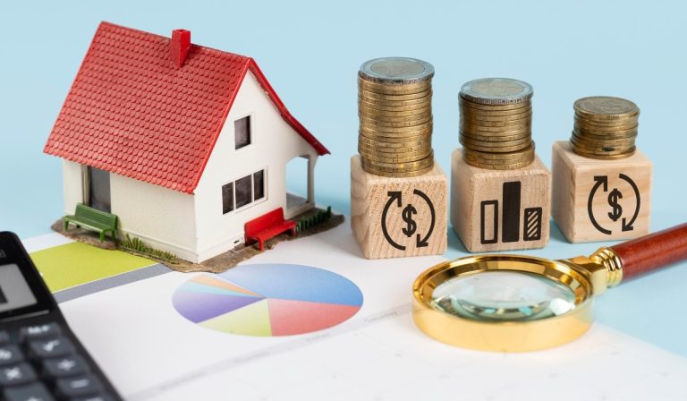 House model and stacked coins under a magnifying glass illustrating the impact of mortgage interest on savings.